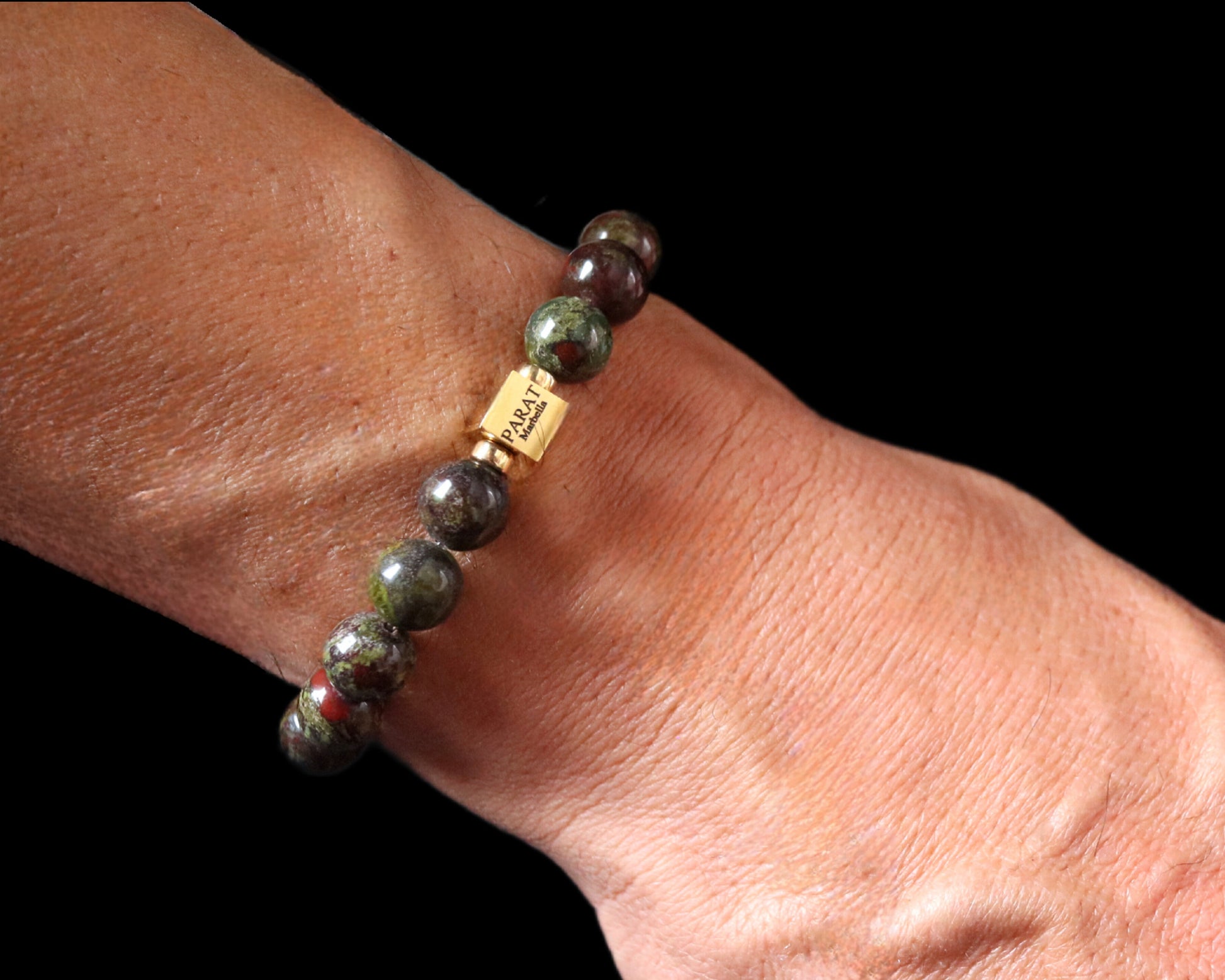 Close-up 14K gold PARAT cube on Bloodstone warrior bracelet worn - lifestyle detail