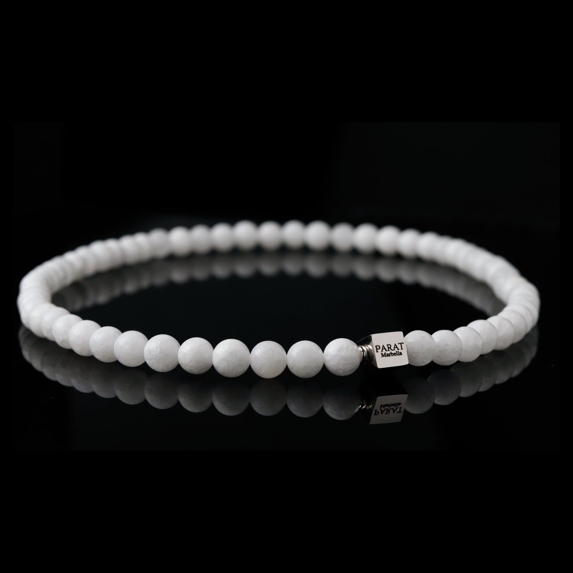 White jade beaded necklace with a brand logo Parat Marbella on a black background