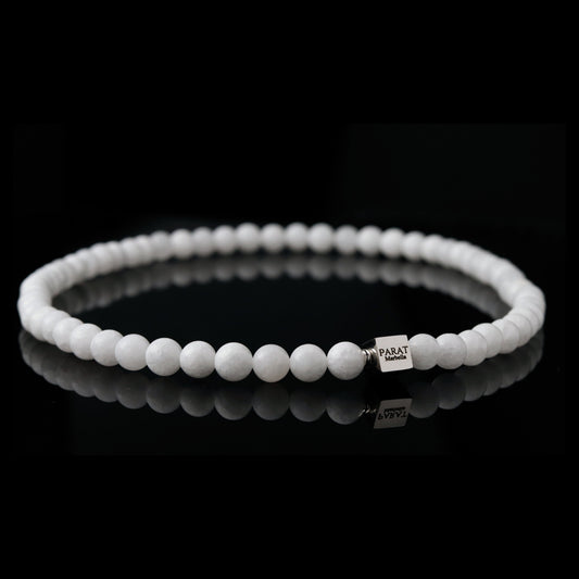 White jade beaded necklace with a brand logo Parat Marbella on a black background